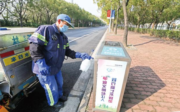 新森林環衛工人正在龍城路對道路邊放置的垃圾桶進行消毒。圾桶進行消毒。